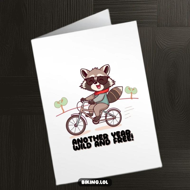 Funny free printable birthday card showing a jolly raccoon speedily descending a hill on a comically small tandem bicycle.