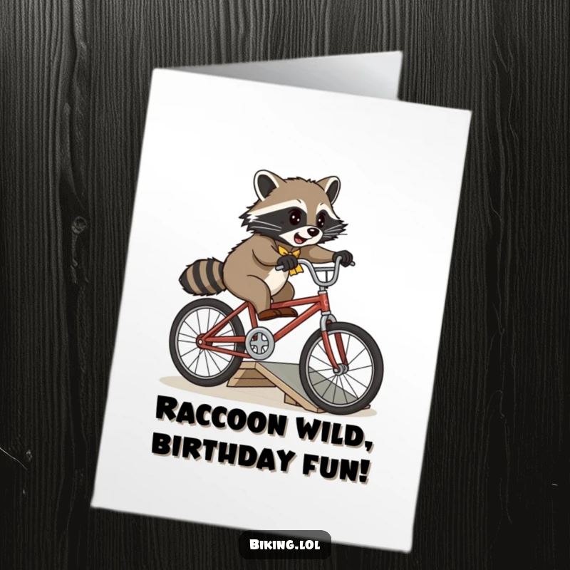 Funny Free Printable Birthday Card: A playful raccoon attempts a jump with a vintage bicycle over a small ramp.