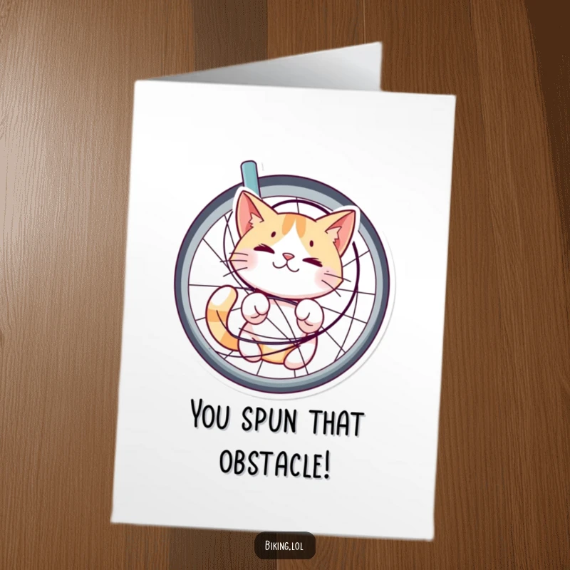 Funny Free Printable Congratulations card: A bewildered but content cat is stuck in bicycle spokes, celebrating nonetheless.