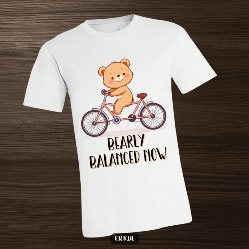 Funny t-shirt showing a smiling bear cub struggling to balance on a tandem bicycle.
