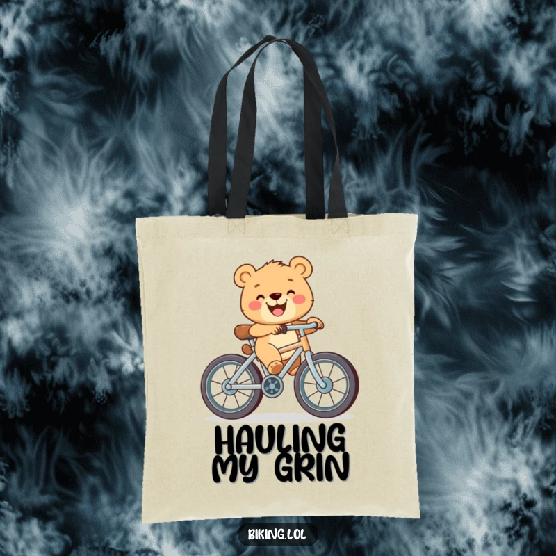 Funny tote bag depicting a happy bear cub with a big grin, pedaling a bicycle that has oversized wheels.